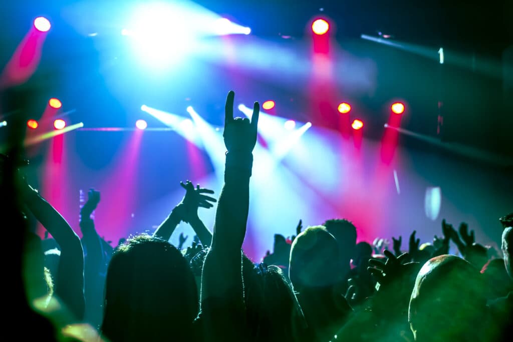 cheering crowd in front of stage lights at a rock concert